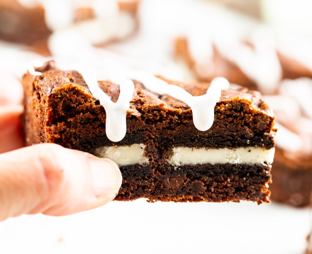 Hand picking up an oreo stuffed brownie.