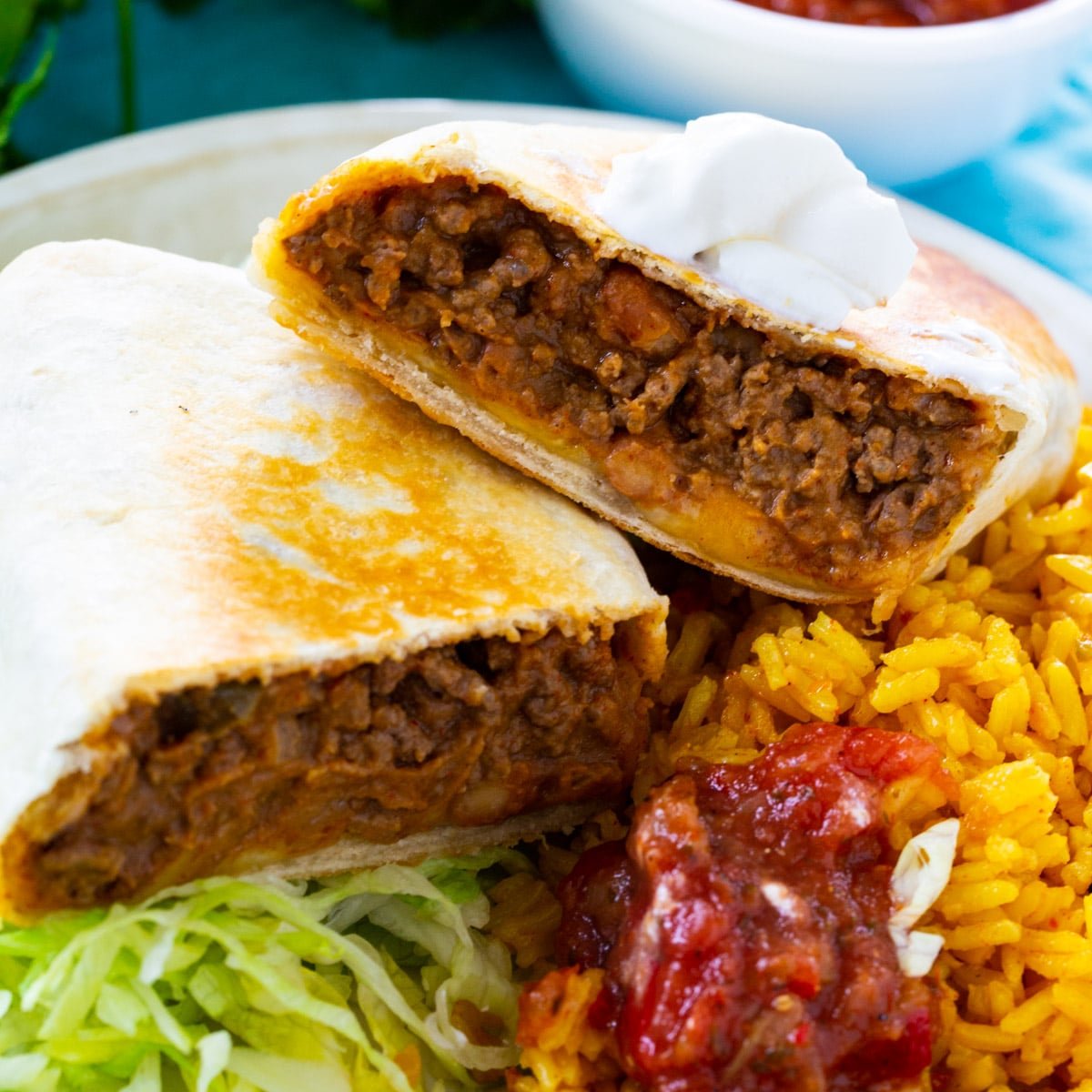 Beef and Bean Burritos on a plate with rice.