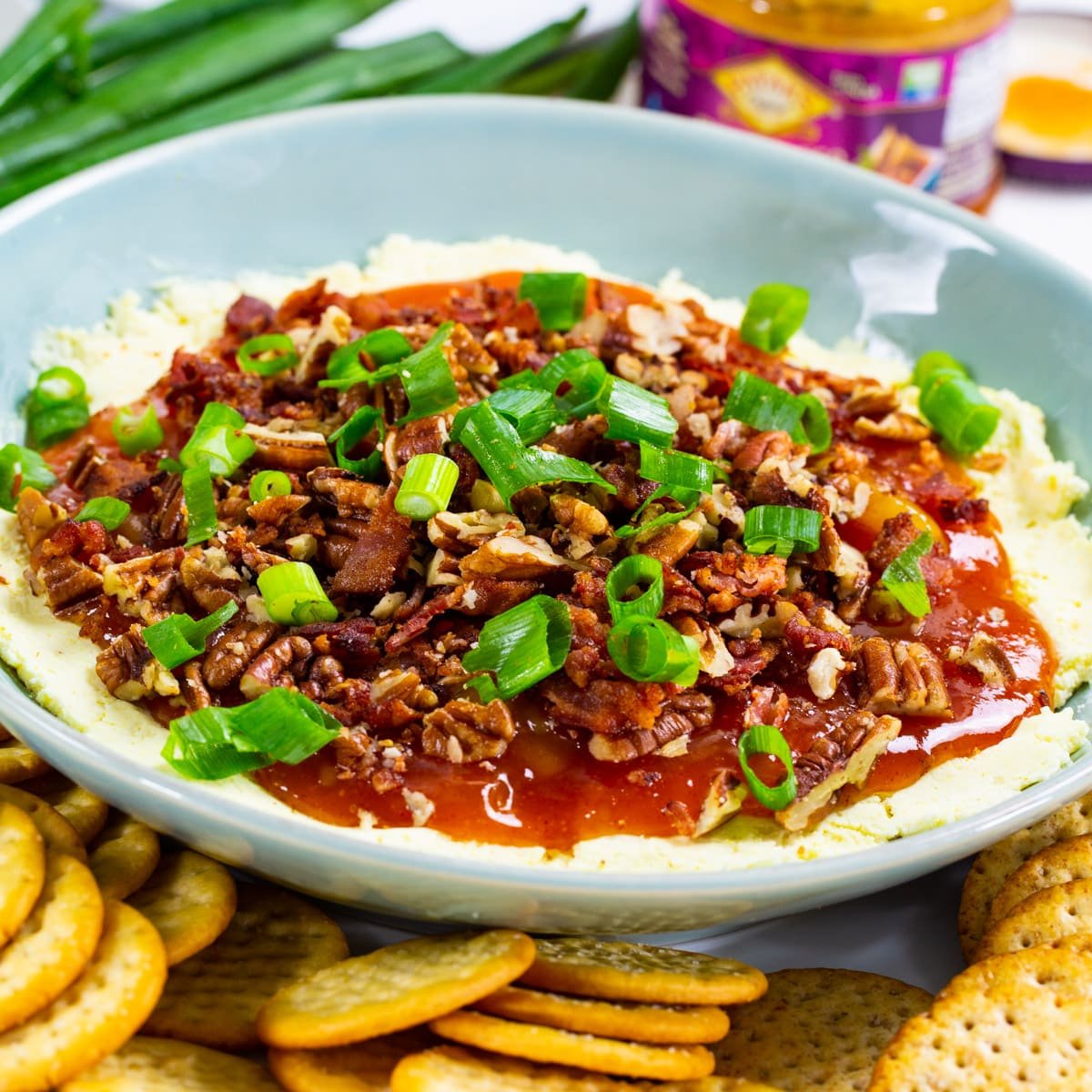 Cheese Dip with Mango Chutney in a bowl surrounded by crackers.
