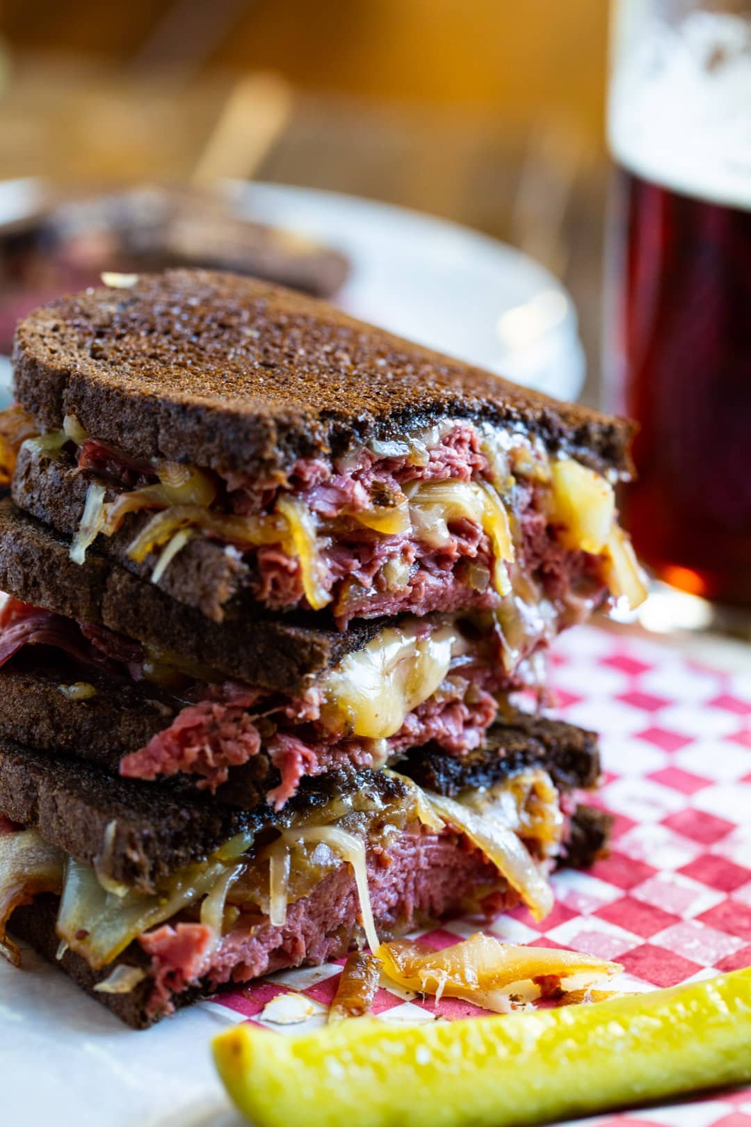 Grilled Cheese halves stacked on tp of each other with a pickle spear.