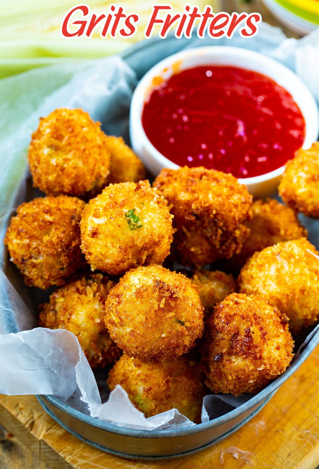 Crispy Grits Fritters in metal serving dish with bowl of dipping sauce.