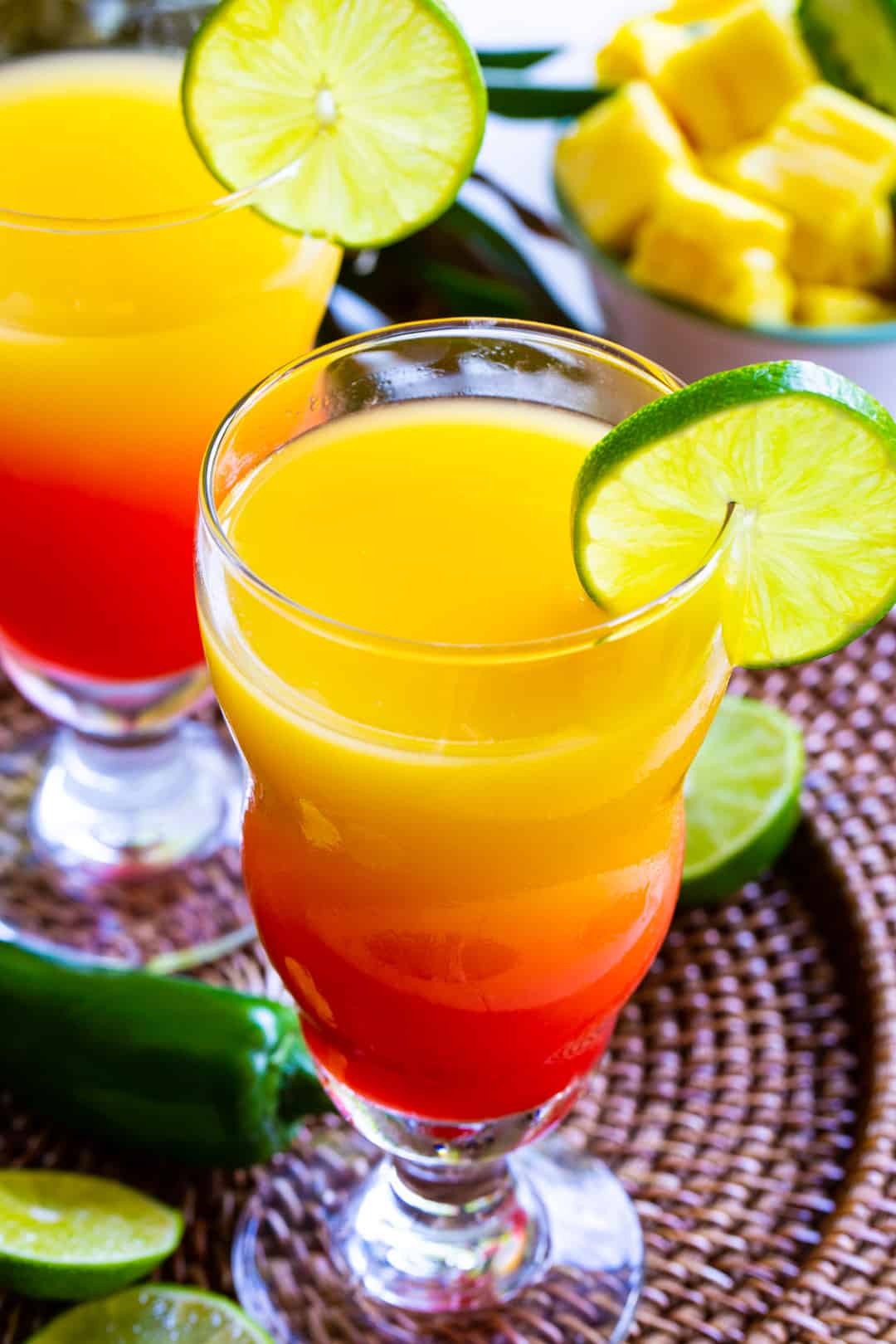 Tequila Sunrise in a glass with lime slice.