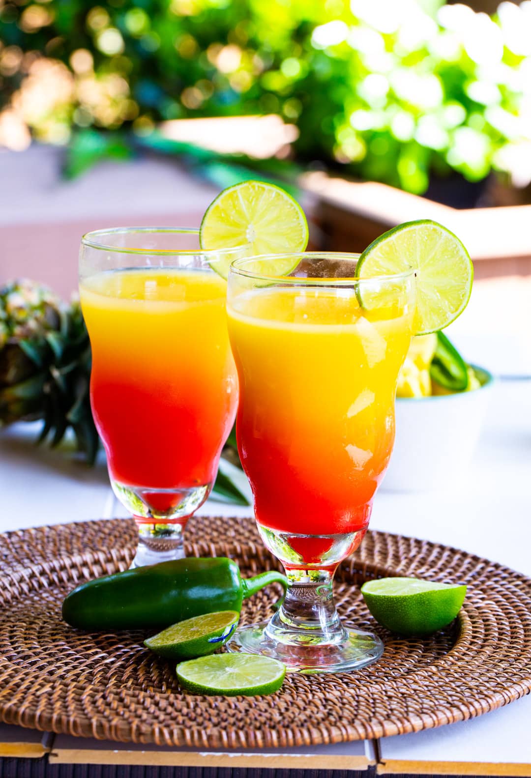 Spicy Tequila Sunrises on a rattan serving tray.