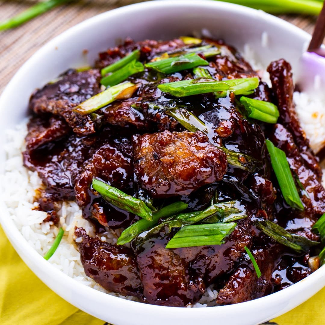 Mongolian Beef over white rice in a bowl.