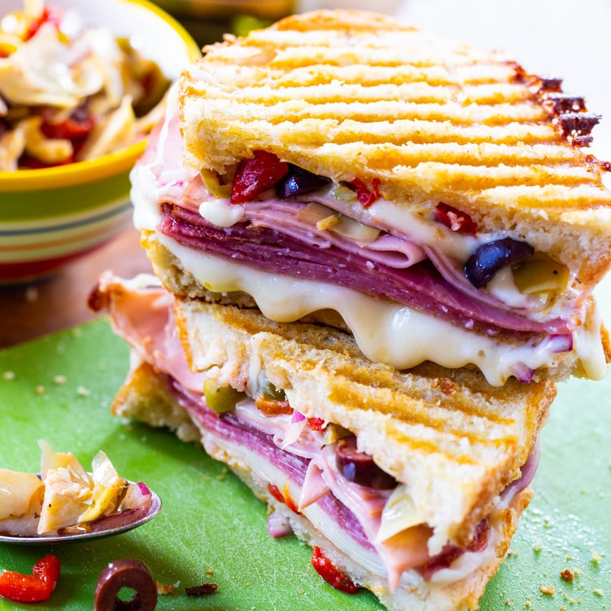 Muffaletta Panini cut in half and stacked.