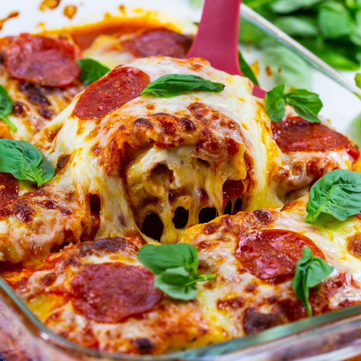 Spatula lifting Pepperoni Lasagna Roll-Ups out of pan.