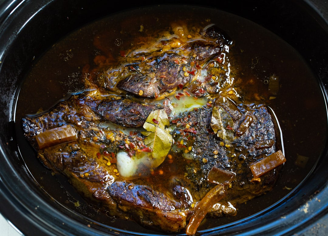 Cooked chuck roast in slow cooker before it is shredded.