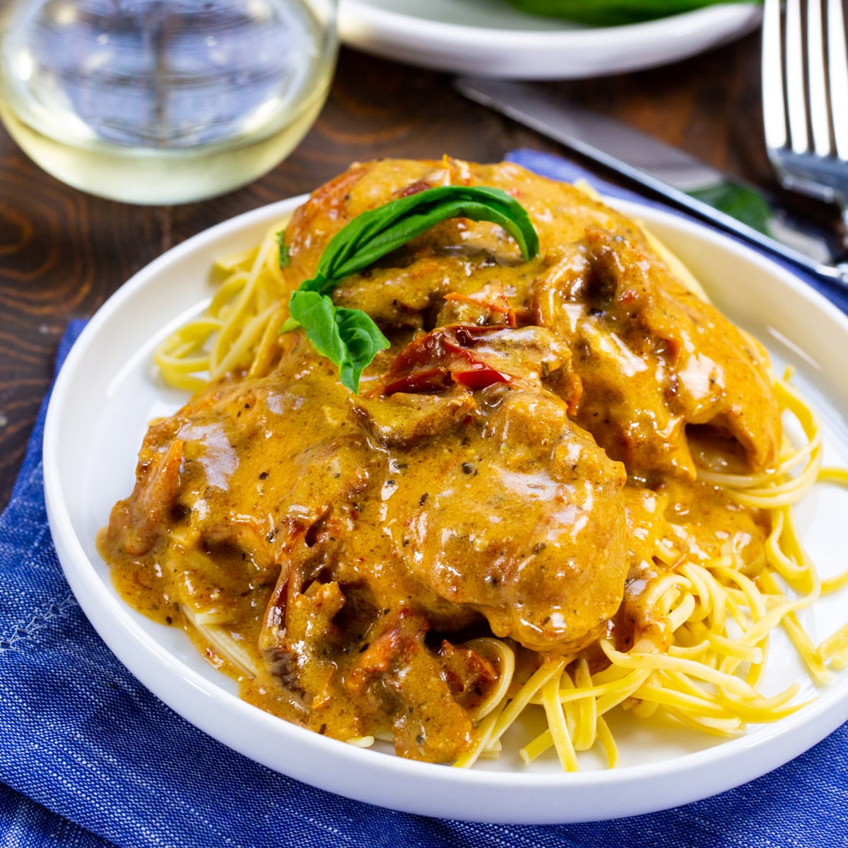 Slow Cooker Marry Me Chicken over pasta on a plate.