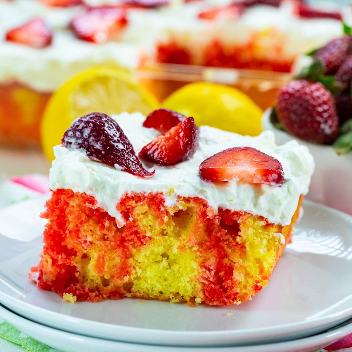 Slice of Strawberry Lemonade Poke Cake on plate.