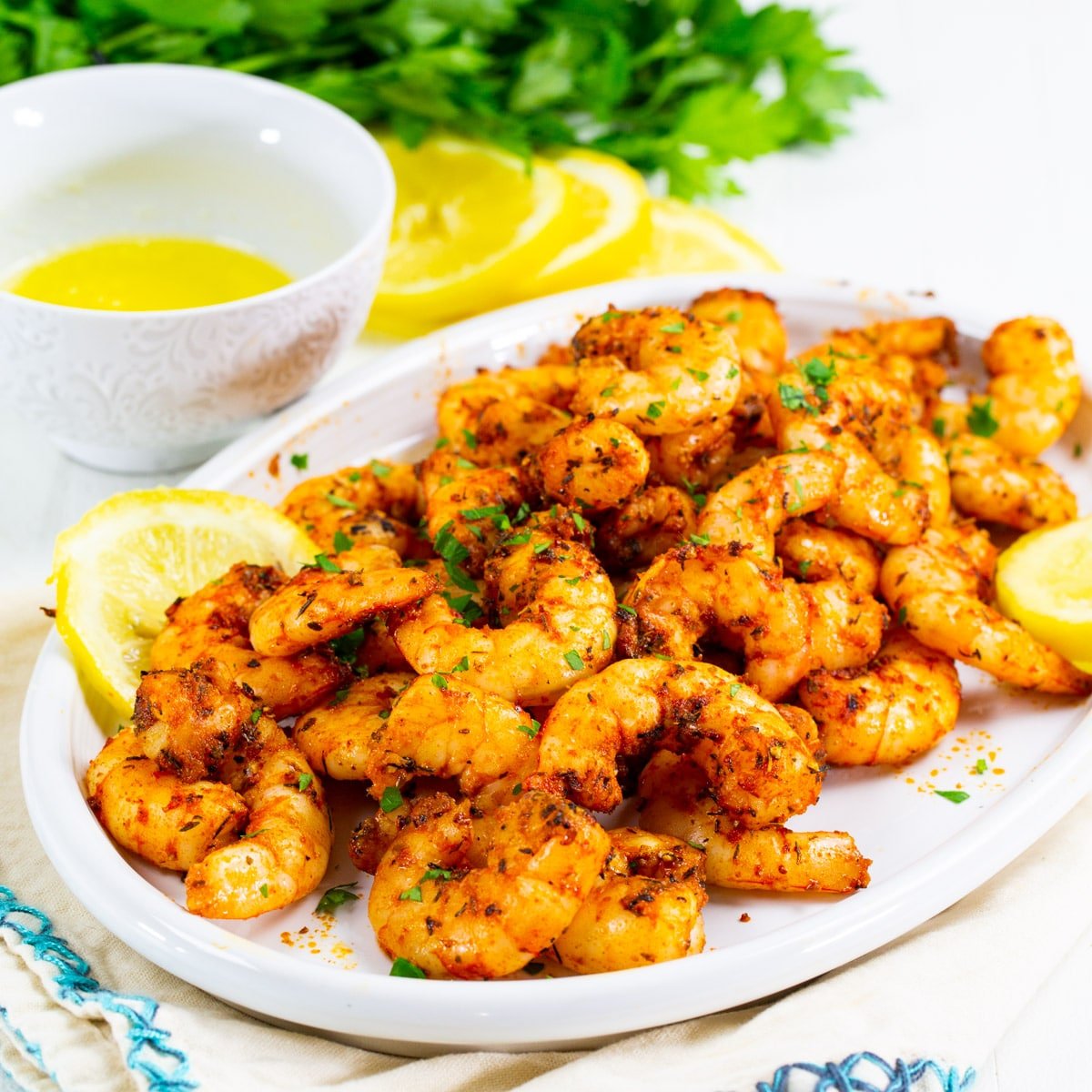 Air Fryer Cajun Shrimp on a plate with lemon slices.