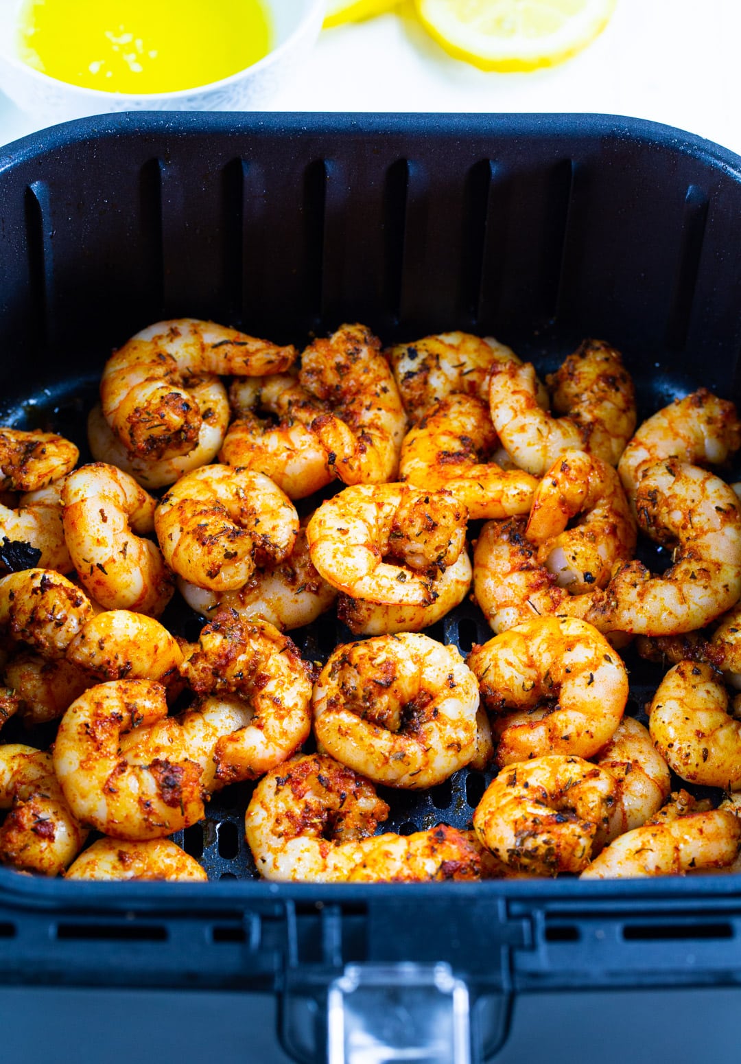 Cooked shrimp in air fryer basket.