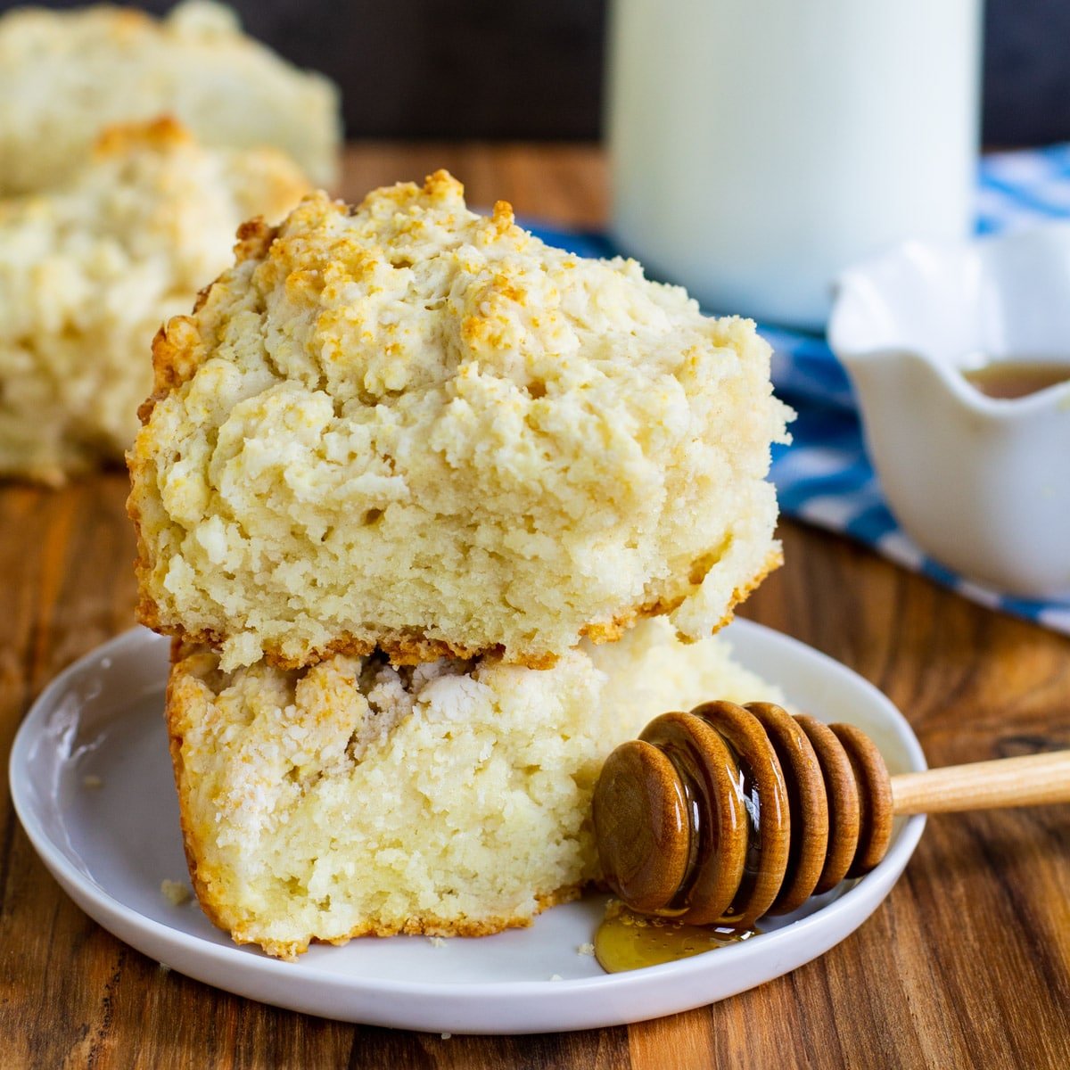 Two Cat Head Biscuits stacked on a plate.