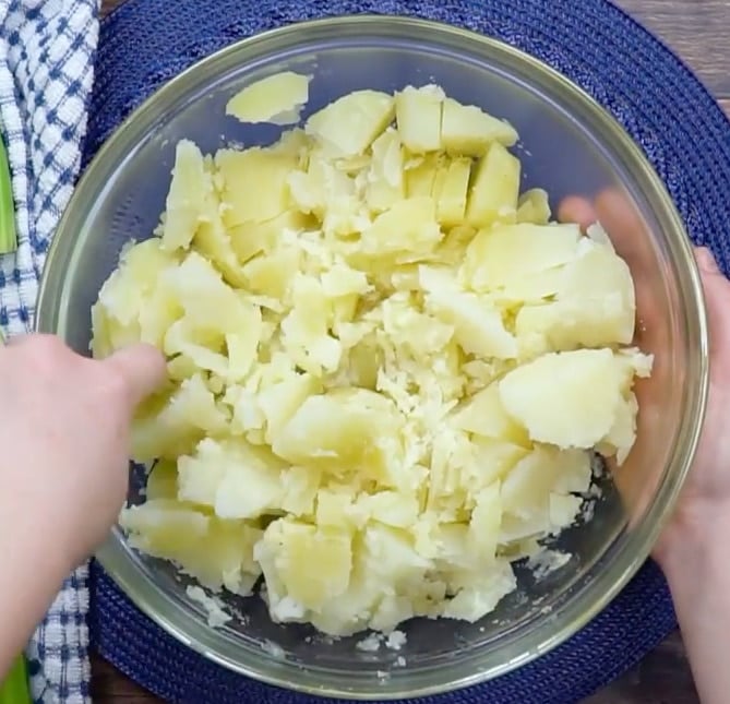Cutting up cooked potatoes.