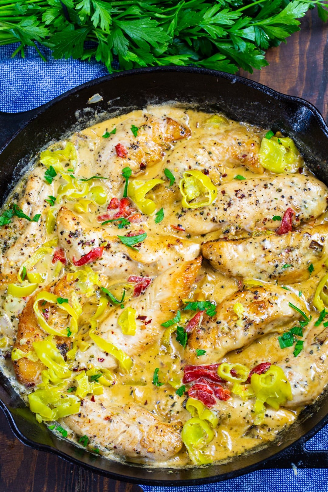 Finished chicken with pepperoncini peppers in a skillet.