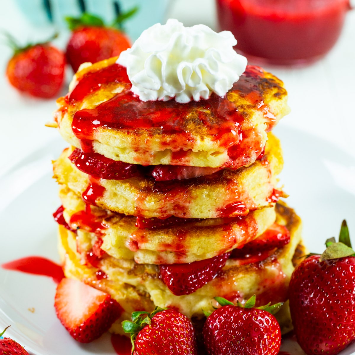Stack of Strawberry Shortcake Pancakes topped with whipped cream.