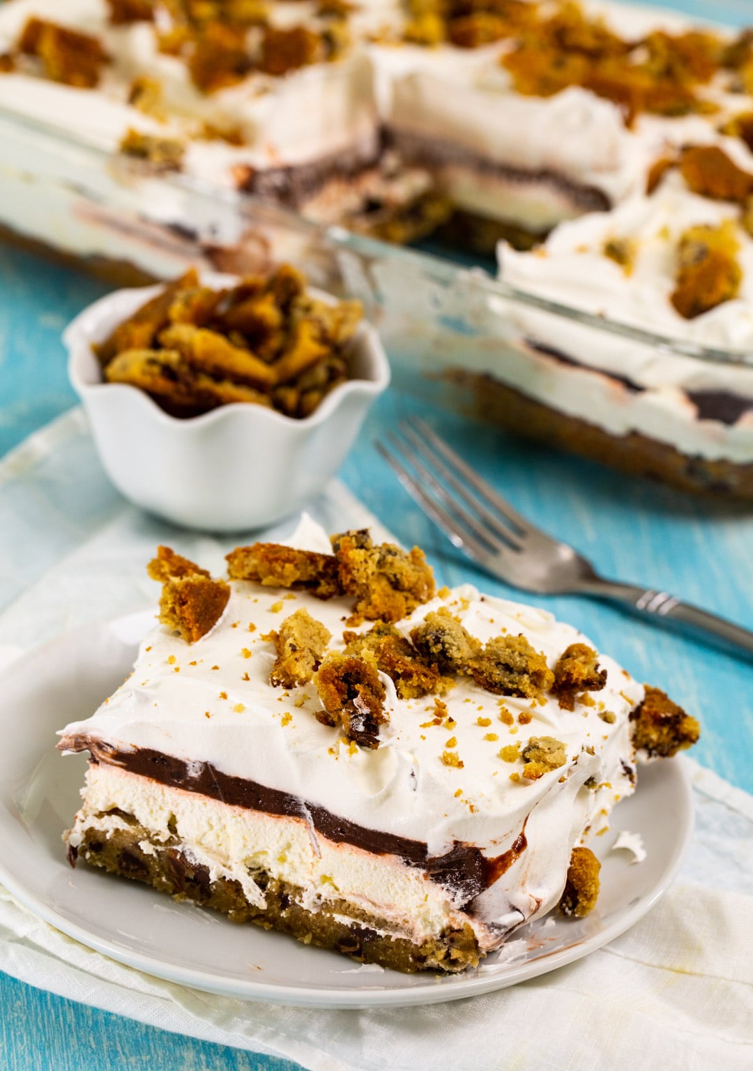 Chocolate Chip Cookie Delight square on a small plate with rest in a baking dish in background.