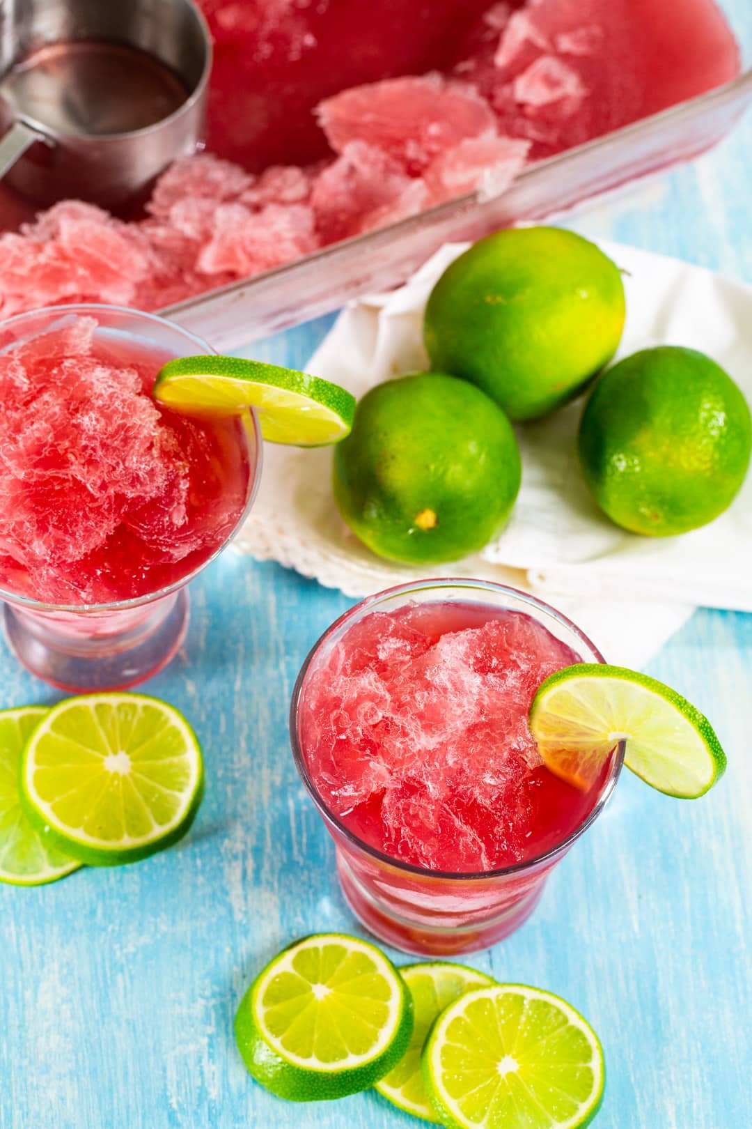 Cosmo Slushie in a glass and fresh limes.