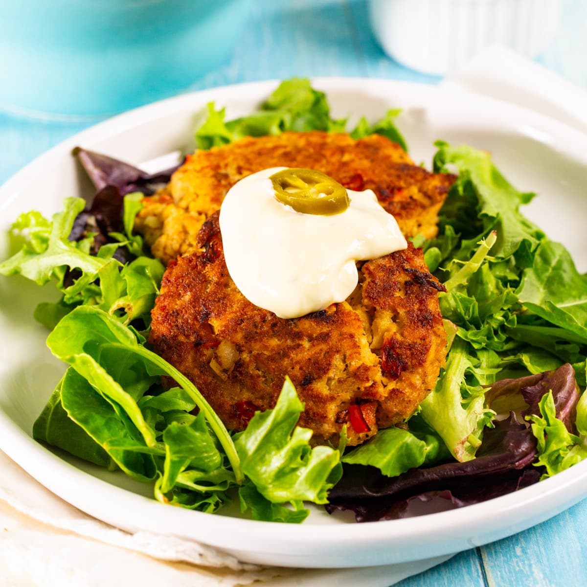 Cajun Salmon Cakes on a bed of mixed greens.