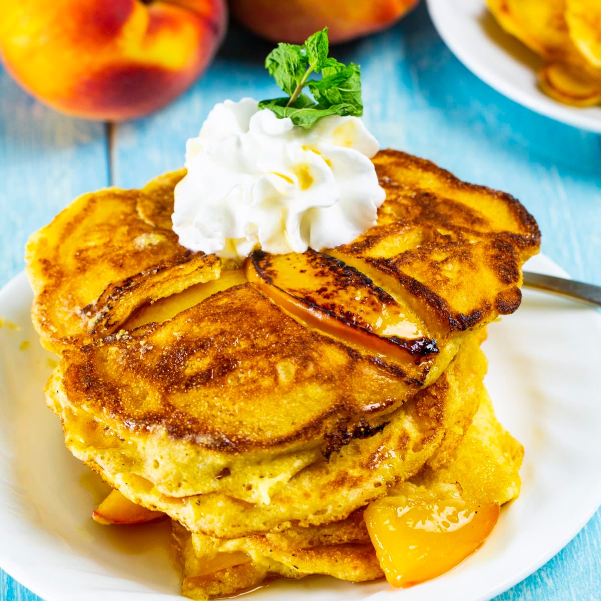 Sweet Peach Pancakes topped with whipped cream.