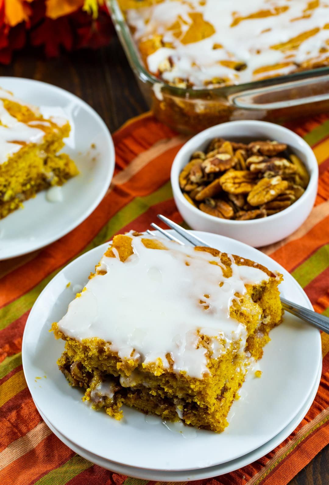 Piece of cake and bowl full of pecans.