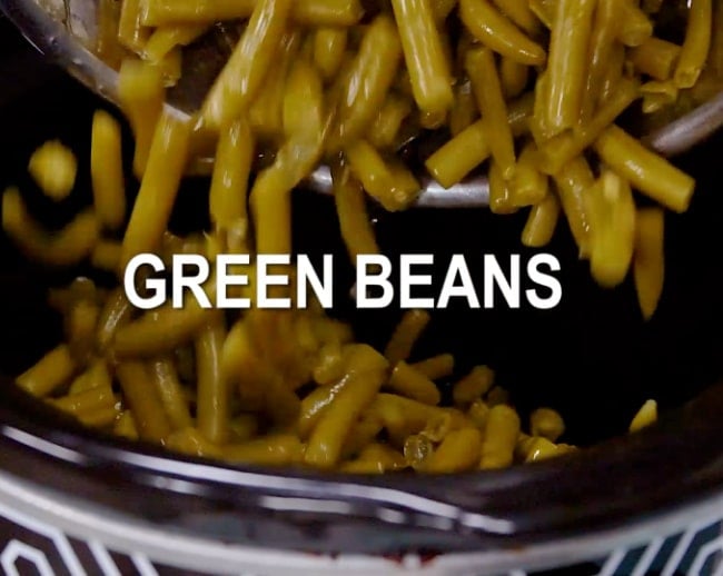 Adding green beans to slow cooker.