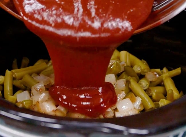 Pouring ketchup mixture into slow cooker.