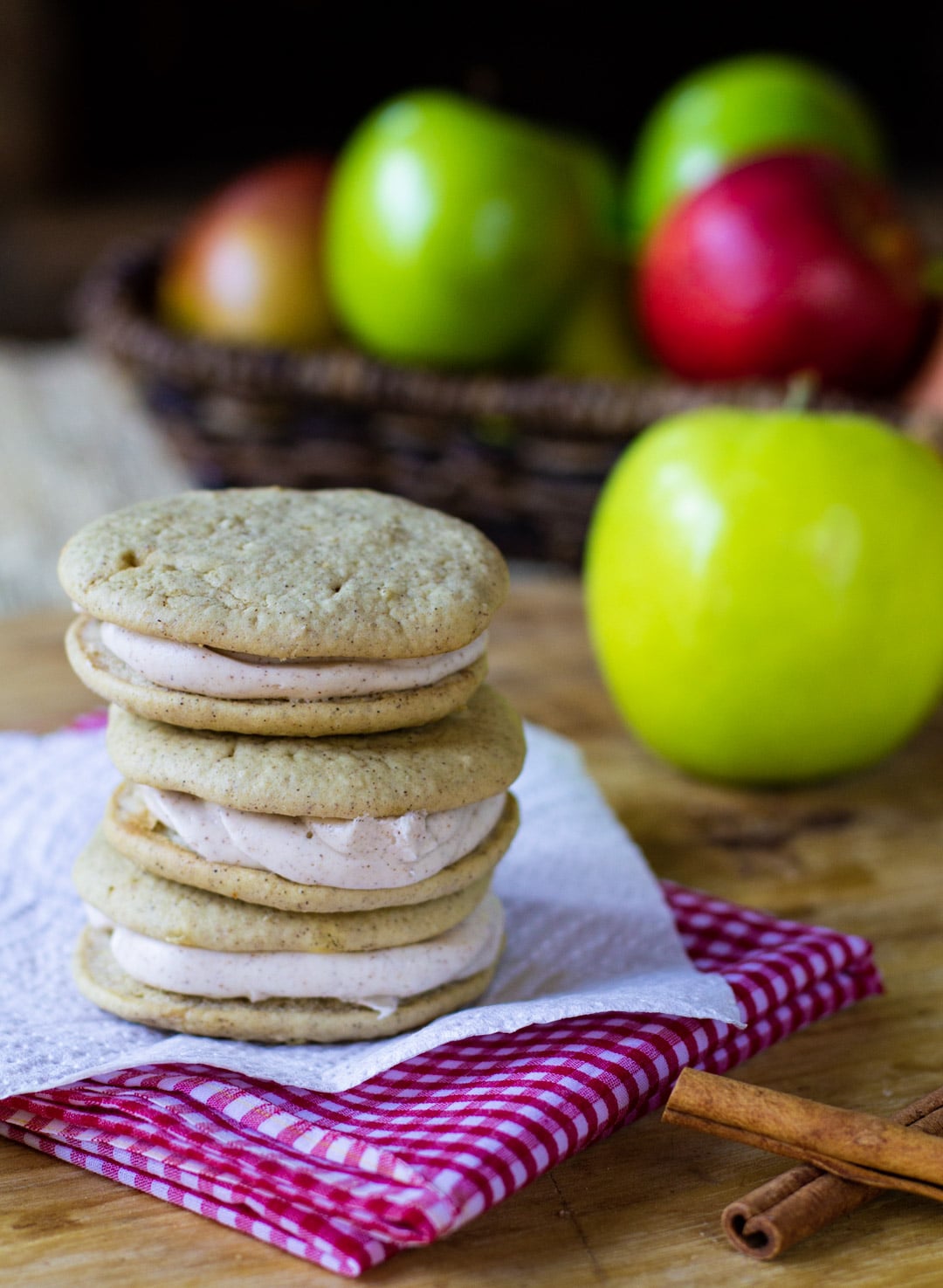 Whoopie pies on a plate and fresh apples in background.