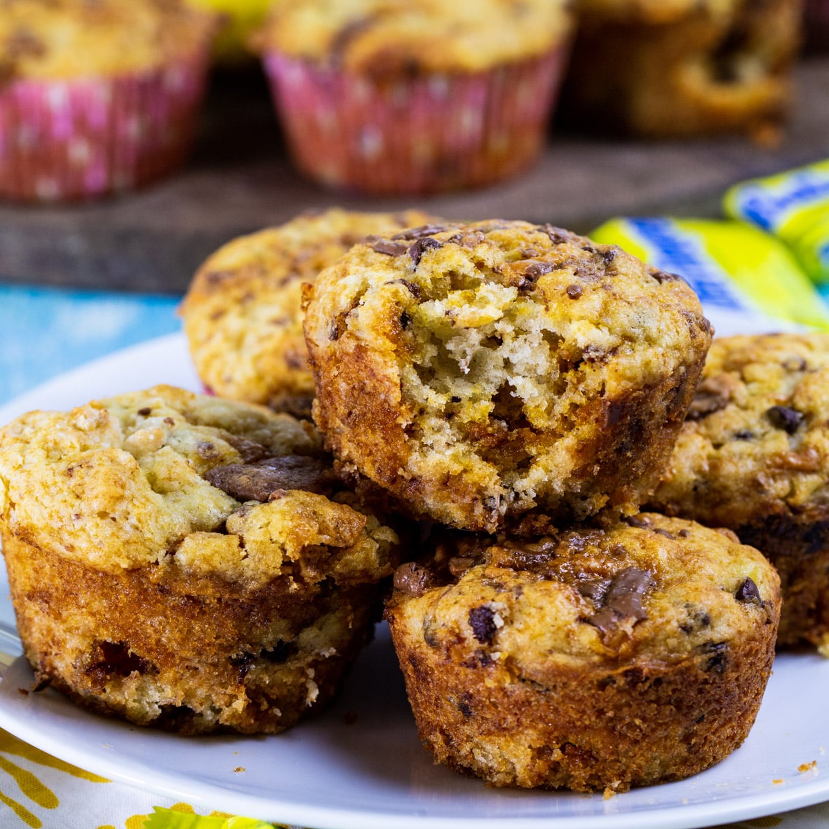 Butterfinger Banana Muffins piled up on a plate.