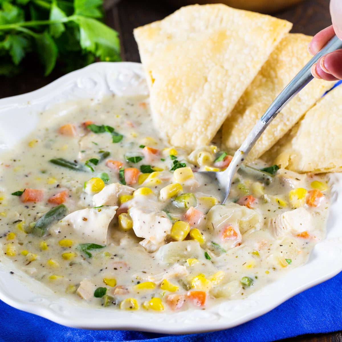 Spoon scooping up soup out of a bowl.