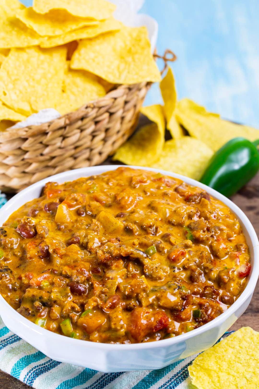 Chili Cheese Dip in a bowl and basket full of chips.