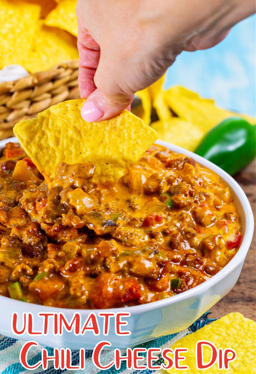 Hand dipping chip into cheese dip.