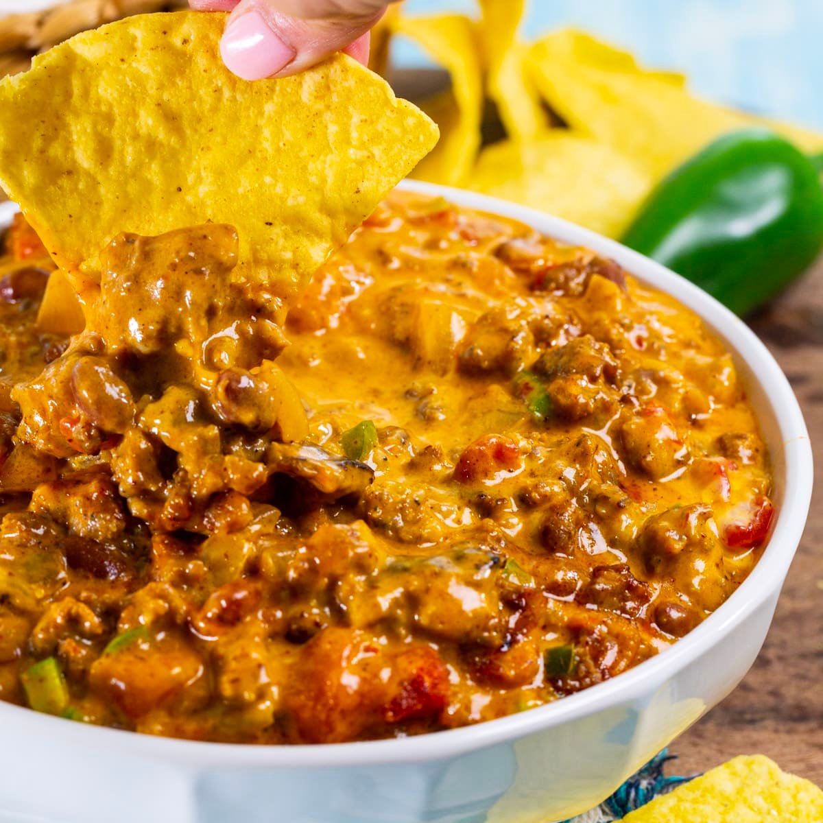 Chip being dipped into bowl of Ultimate Chili Cheese Dip.