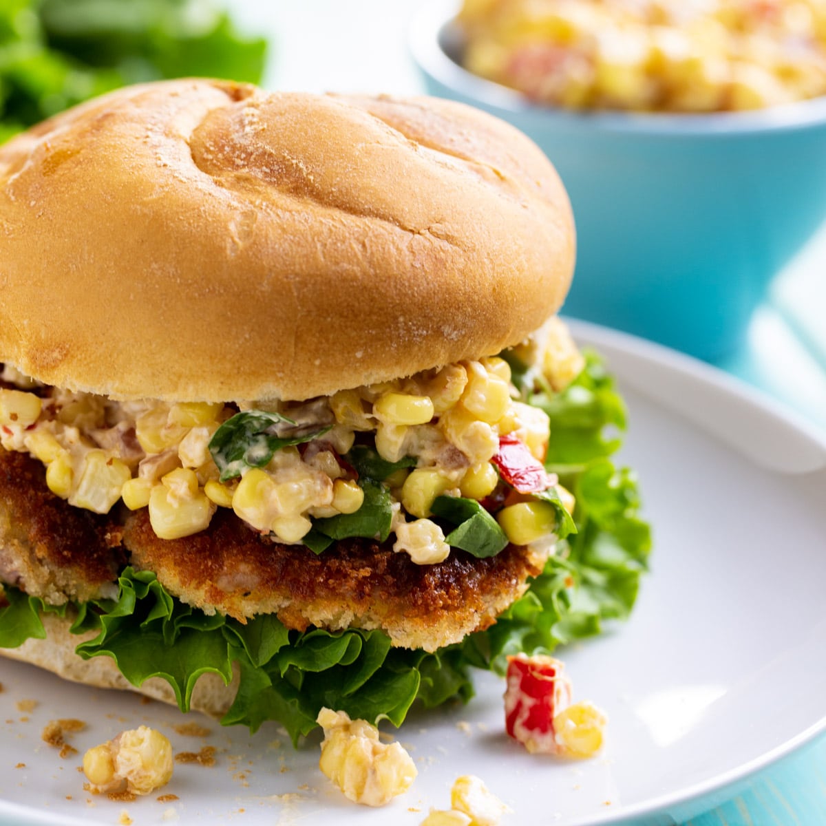 Indiana Pork Tenderloin Sandwich with corn relish on a plate.