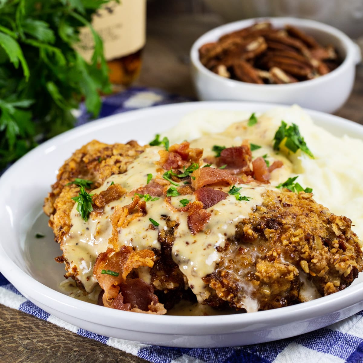 Pecan Chicken in Bourbon Maple Cream Gravy on a plate with mashed potatoes.