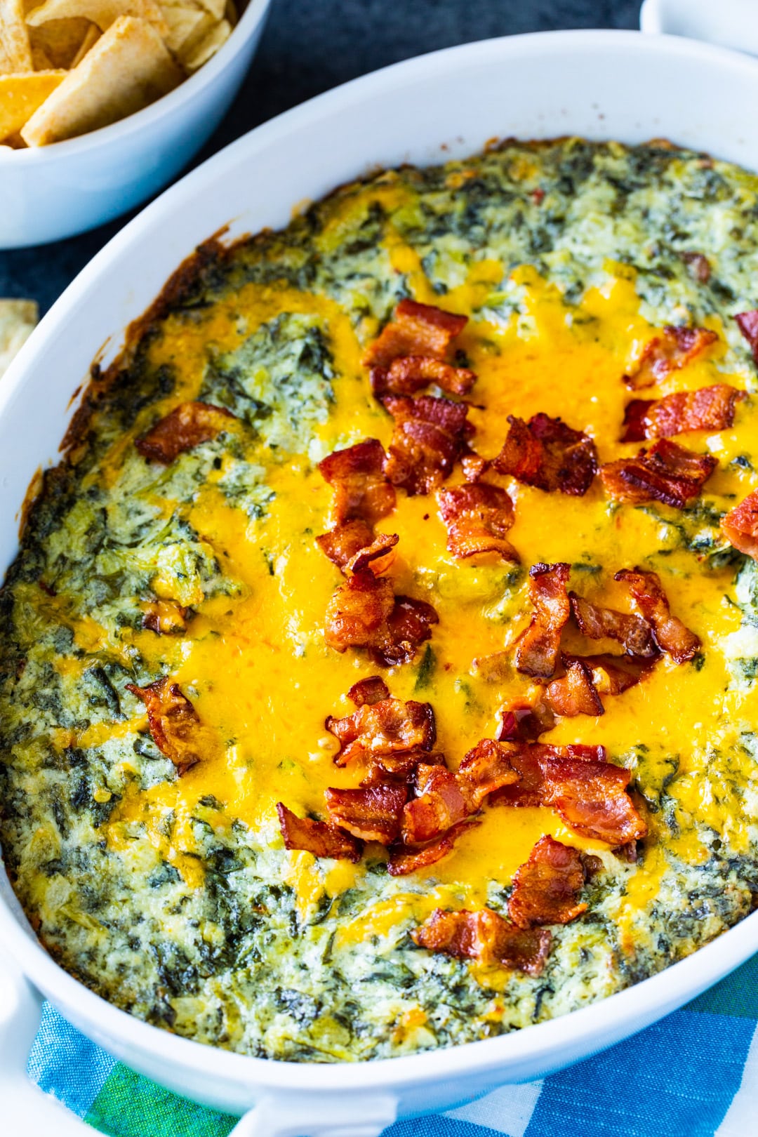 Dip covered with bacon in casserole dish.