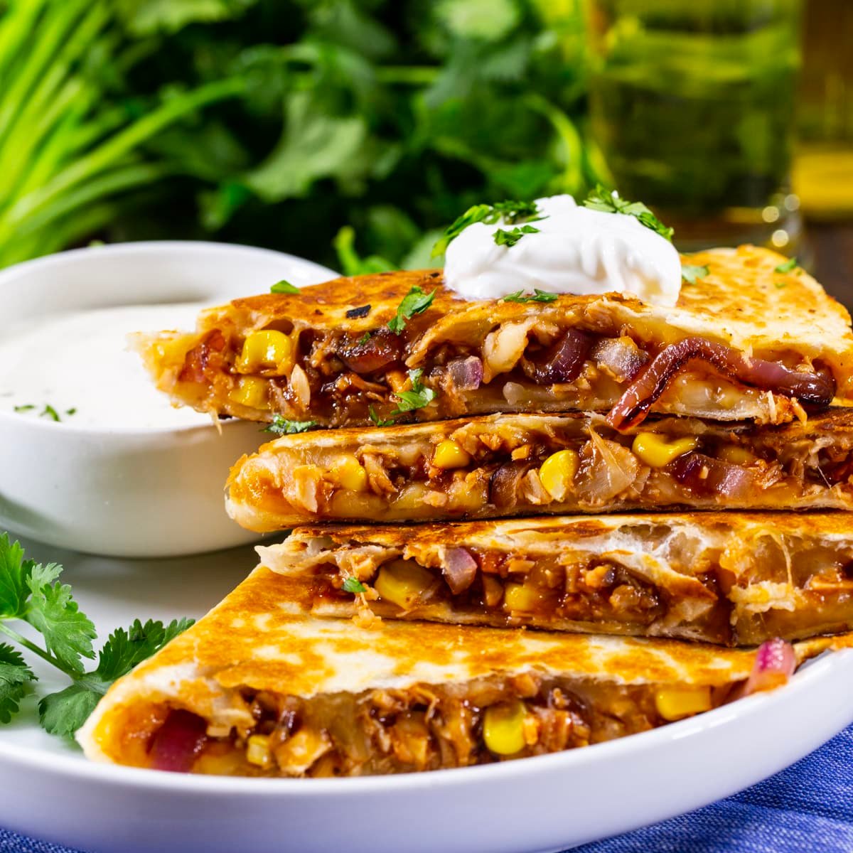 BBQ Chicken Quesadilla chopped  into wedges and topped with sour cream.