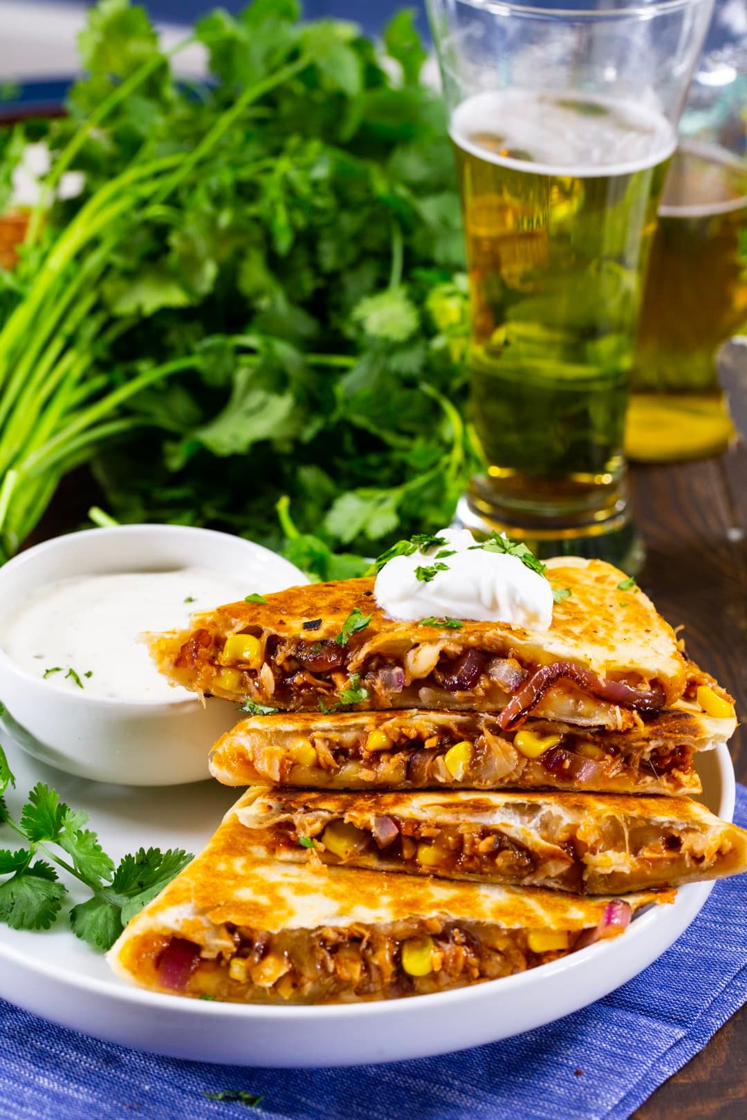 Quesadilla on a plate and glass of beer.