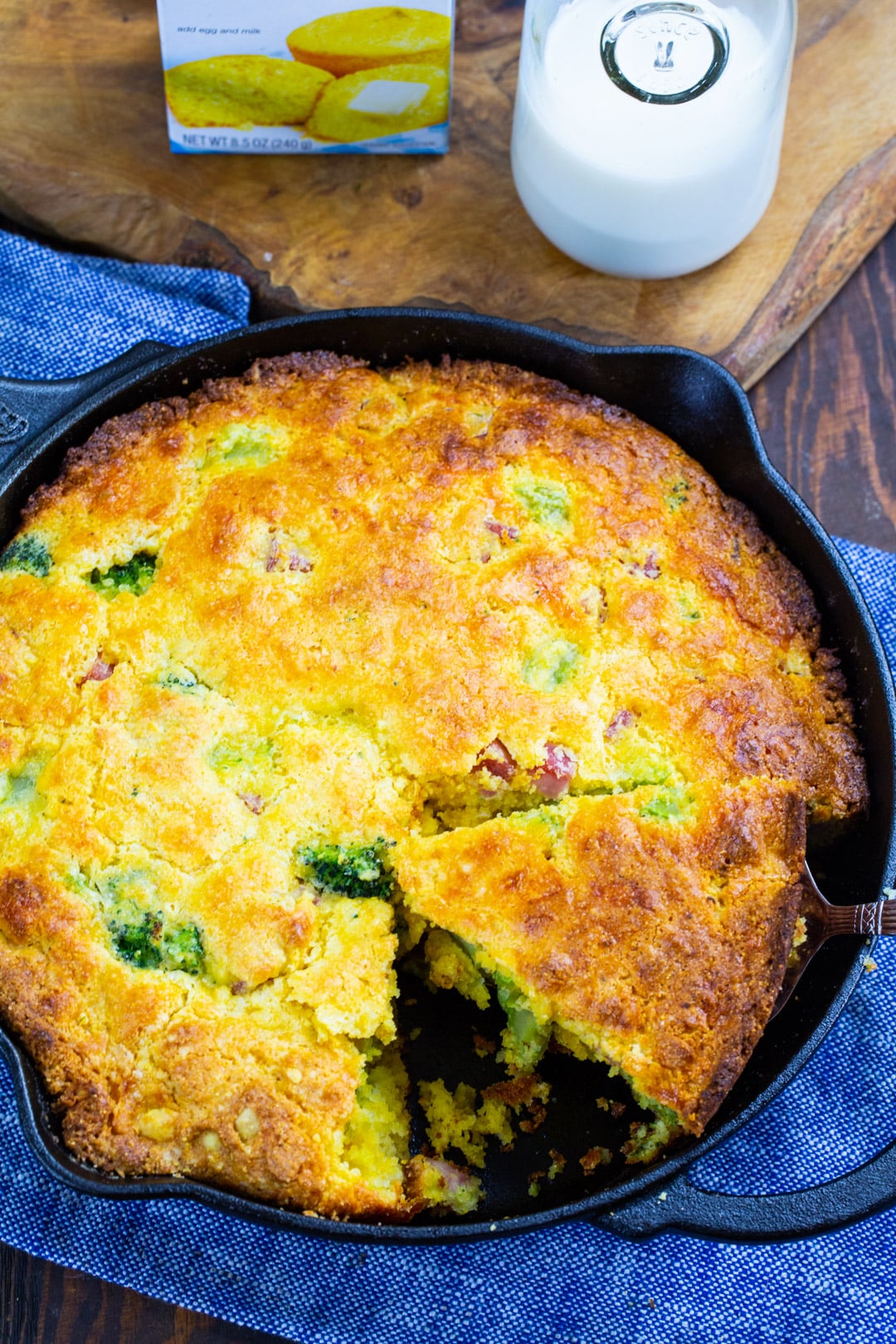 Cornbread in a skillet with slice removed.