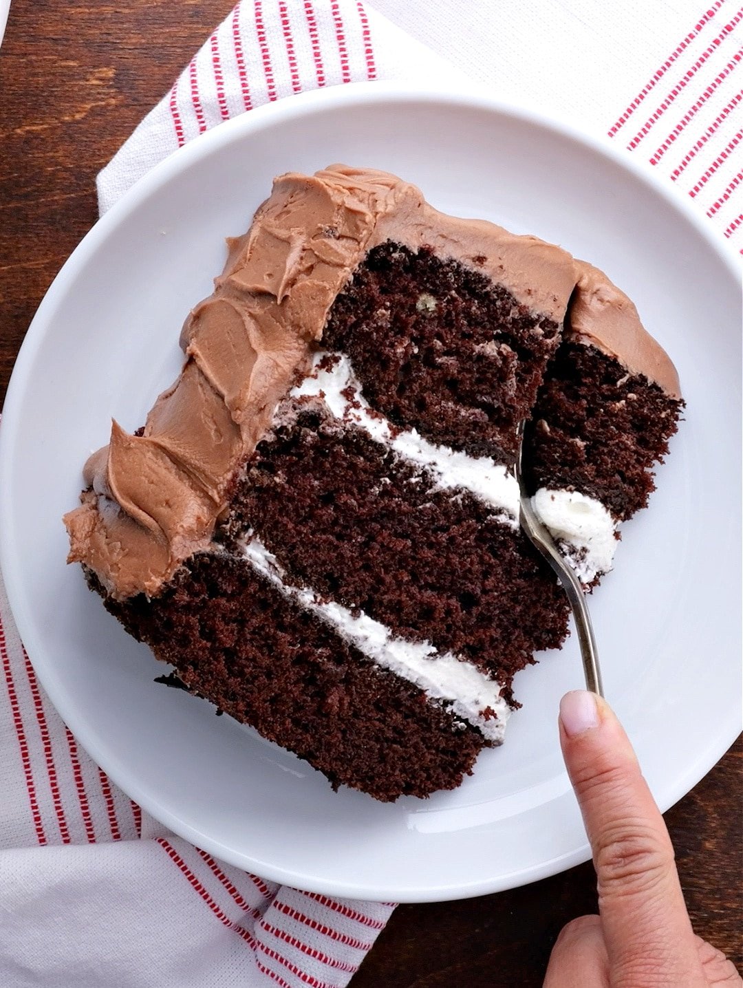 Fork cutting into slice of cake.