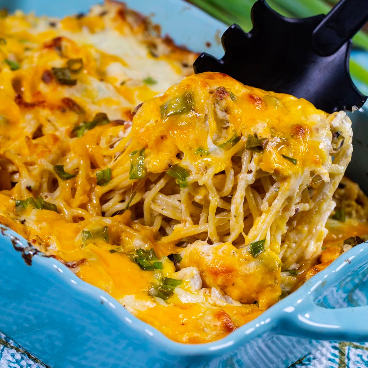 Crack Chicken Pasta being scooped out of casserole dish.