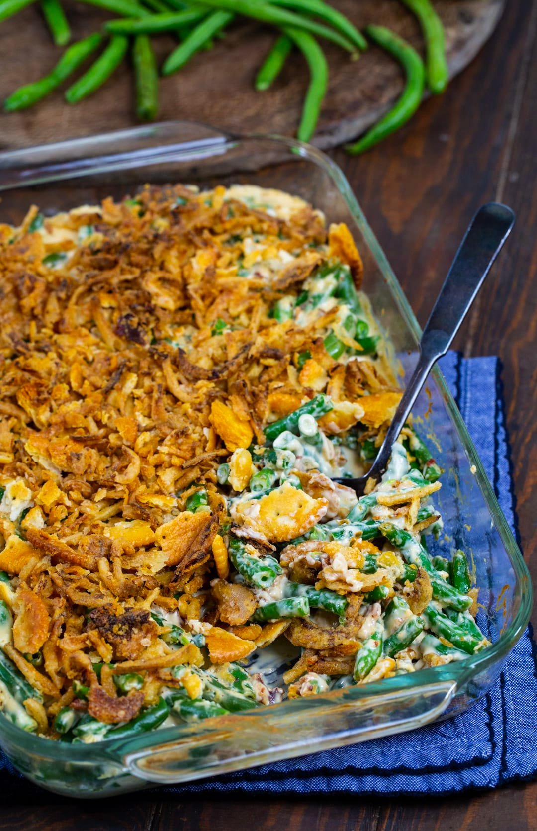 Spoon scooping casserole out of baking dish.