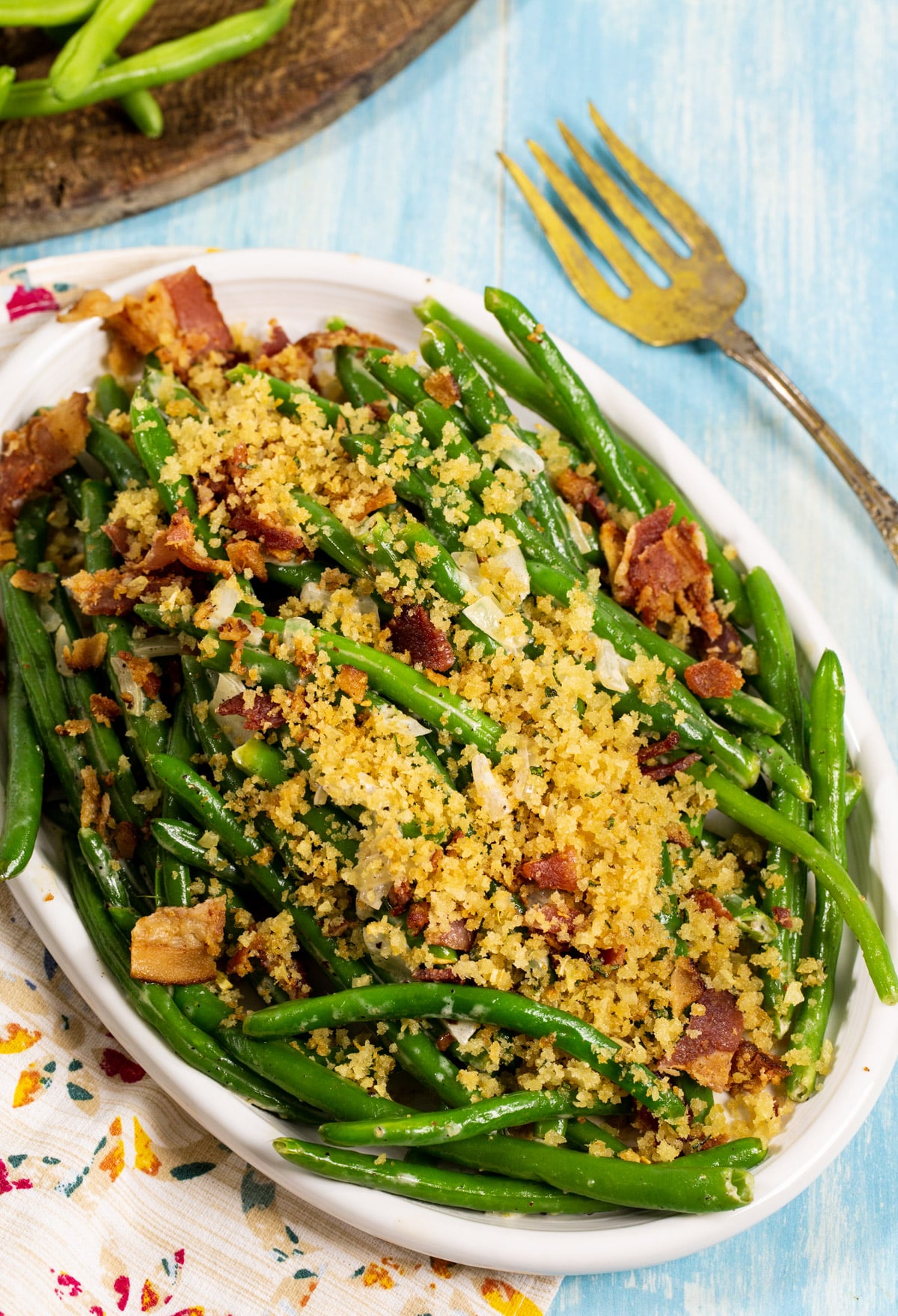 Green beans on a serving platter. Topped with Panko crumbs and bacon.