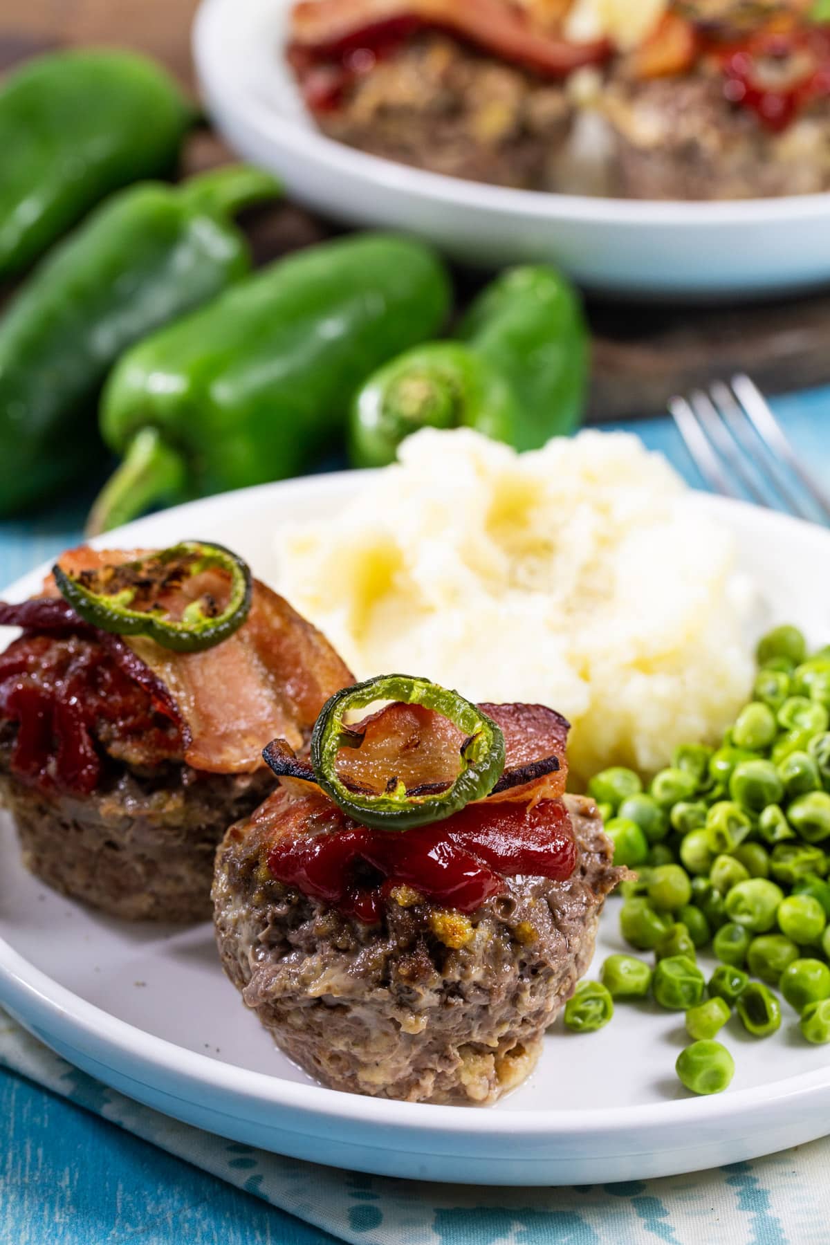 Two Jalapeno Popper Meatloaf Muffins on a plate.