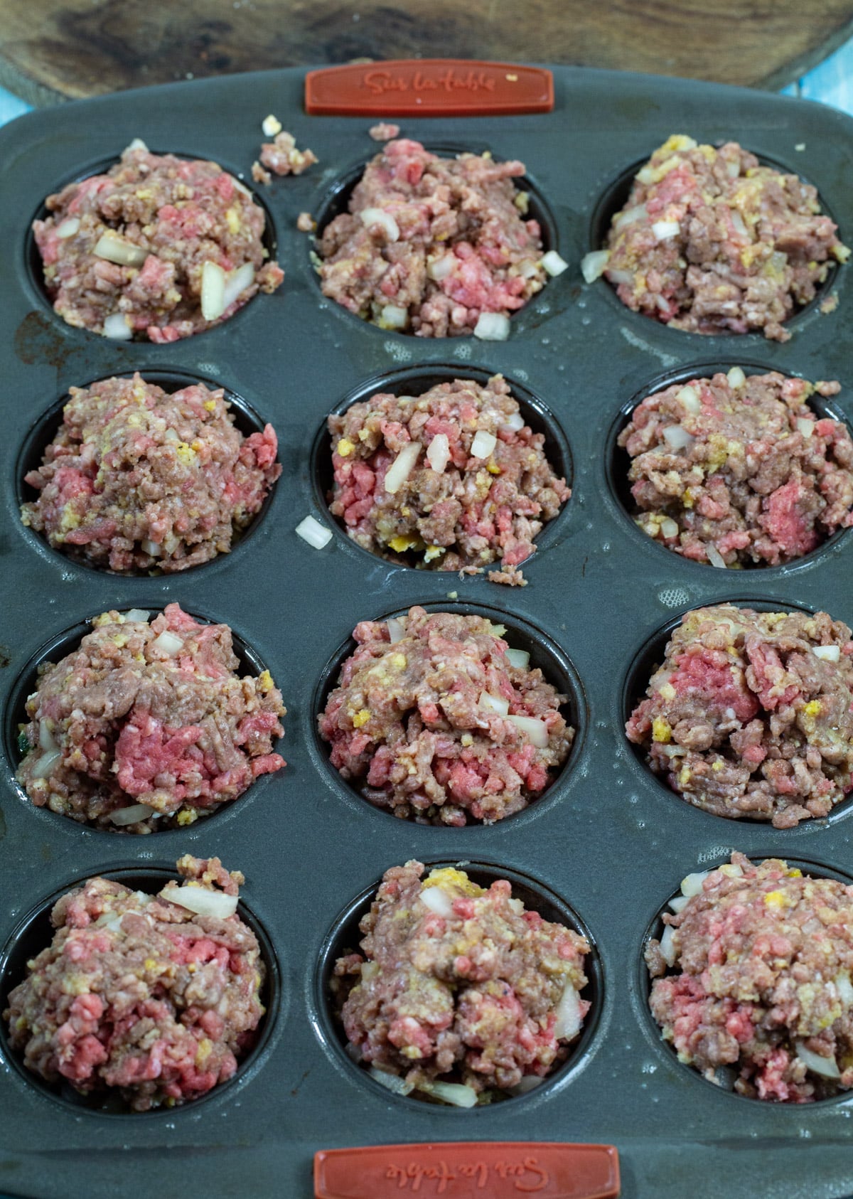 Unbaked meatloaf in muffin cups.