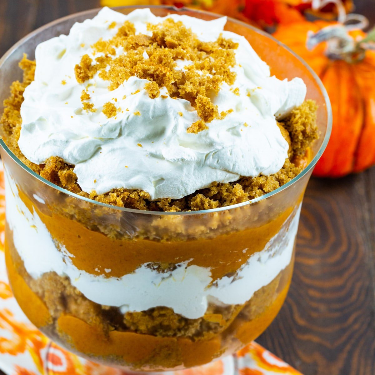 Trifle topped with whipped cream in a trifle bowl.