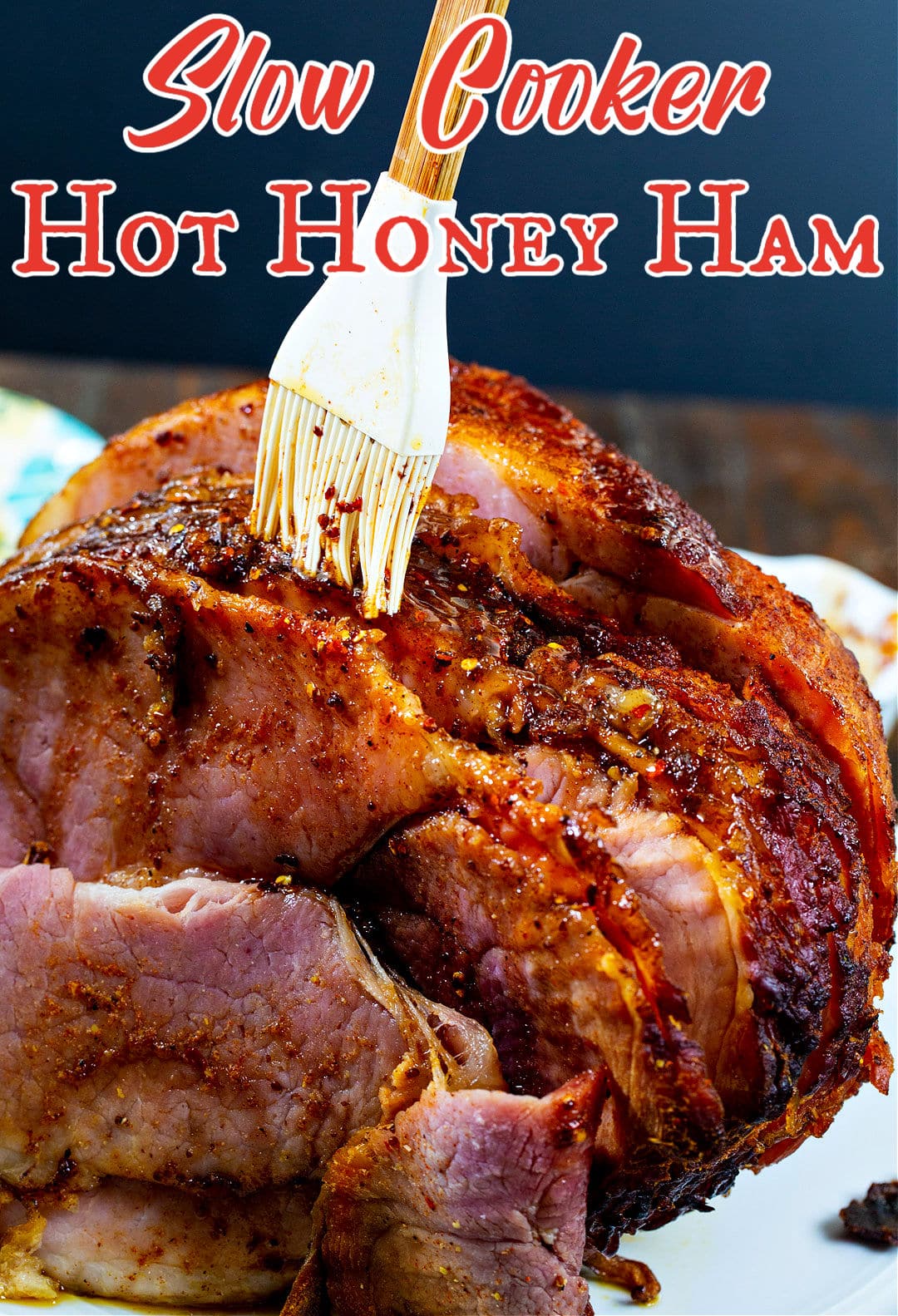 Slow Cooker Hot Honey Ham being brushed with glaze.