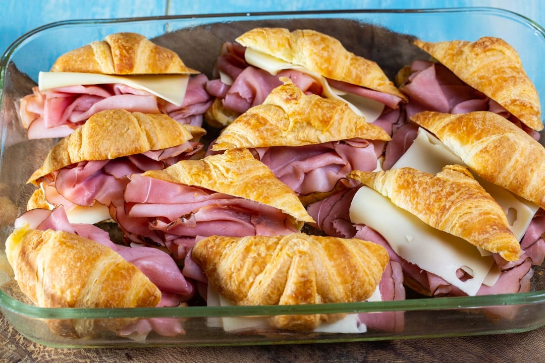 Ham and cheese stuffed croissants in baking dish.