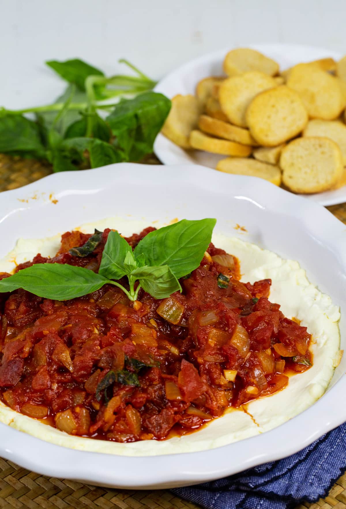 Baked Goat Cheese Dip topped with tomatoes and fresh basil.