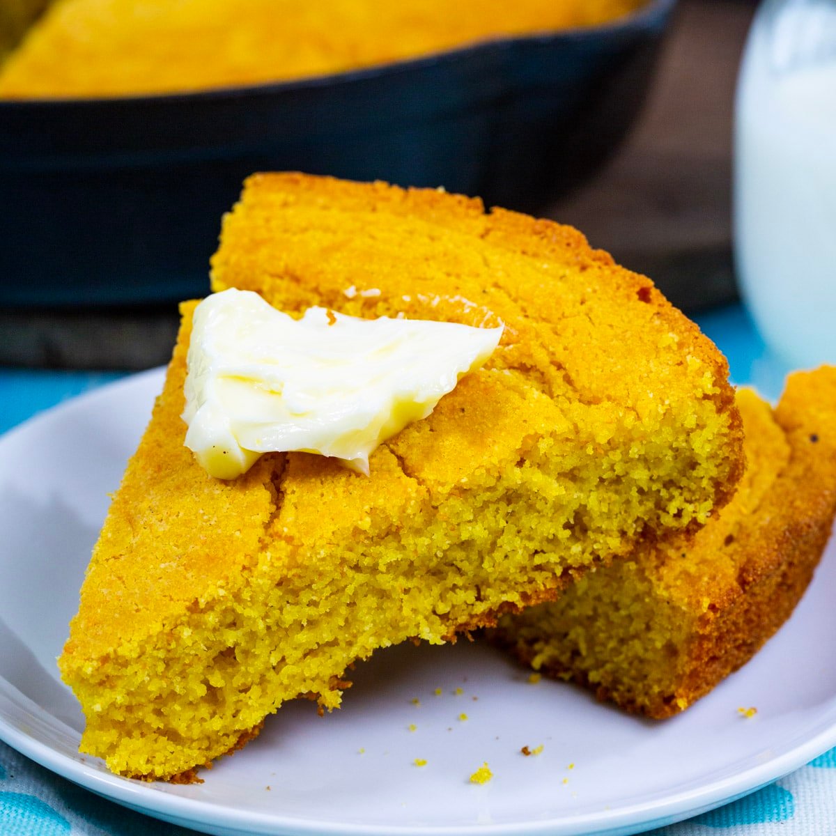 Slices of Buttermilk Cornbread  topped with butter.