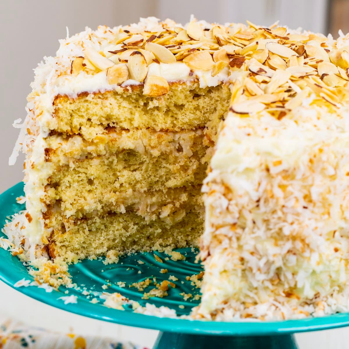 Coconut Almond Cream Cake  with slice cut out.